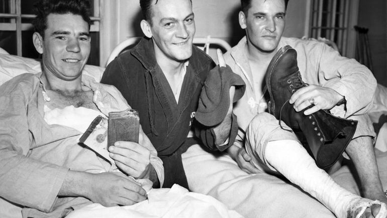 In this May 28, 1943, file photo, soldiers who took part in the American landing on Japanese-occupied Attu in the Aleutians, from left, Pvt. John E. Terknett, of Eastland, Texas, whose wallet and notebook were ripped by a shell which wounded him across the chest, Pvt. Joseph E. Kenski, of Detroit, with a finger through a knitted cap he was wearing when he suffered a head wound, and Sgt. Forrest Wright Johnson, of Flat River, Mo., showing a bullet-creased boot, smile after arriving at a Pacific Northwest Army base hospital. The 75th anniversary of American forces recapturing Attu Island in Alaska's Aleutian chain from Japanese forces will be marked on May 30, 2018. It was the only World War II battle fought on North American soil. (AP)