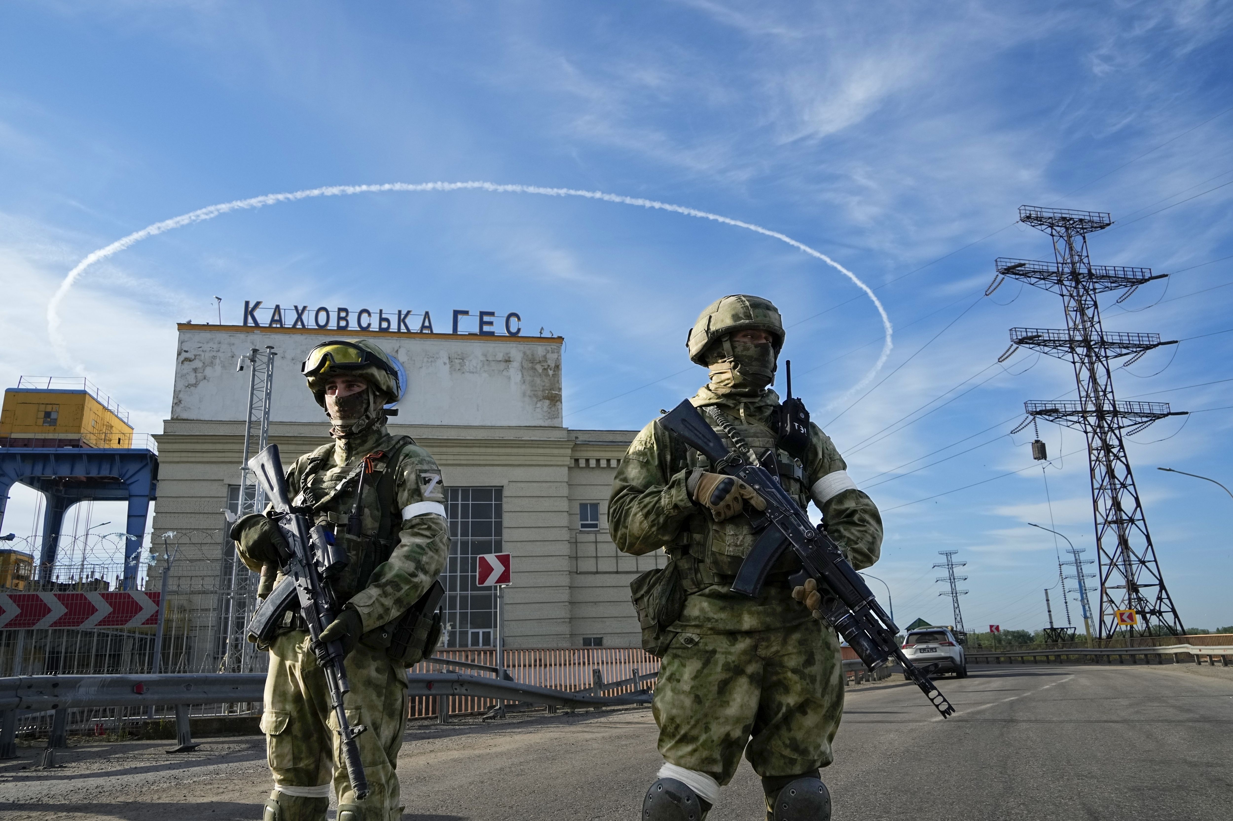 Russian troops guard an entrance of the Kakhovka Hydroelectric Station, a run-of-river power plant on the Dnieper River in Kherson region, south Ukraine, Friday, May 20, 2022. (AP Photo, File)