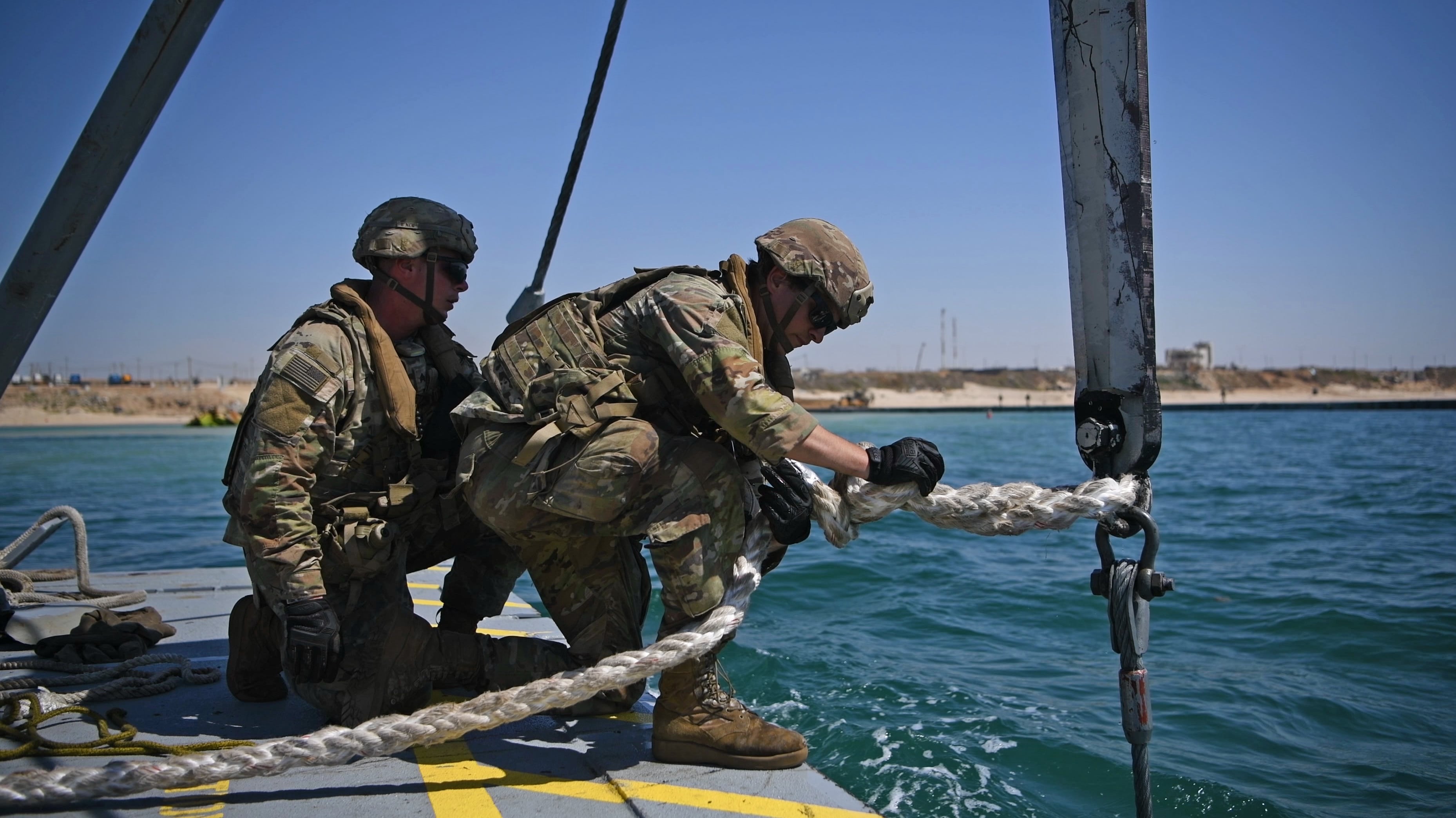 U.S. soldiers assigned to the 7th Transportation Brigade (Expeditionary) use a modular warping tug’s crane to drop temporary anchors to stabilize the aid pier on the Gaza coast on June 7. (Mass Communication Specialist 1st Class Jordan  KirkJohnson/Navy)