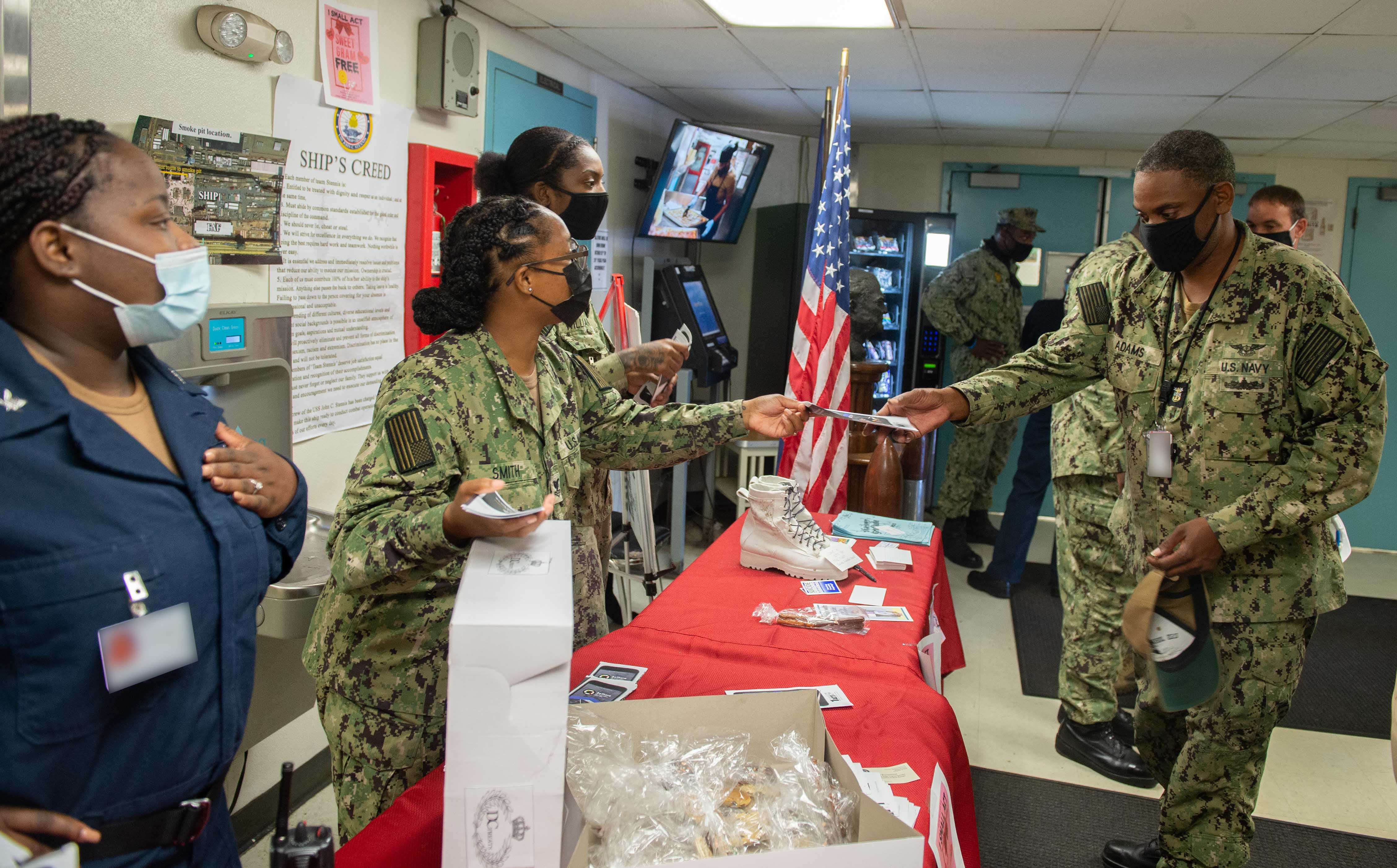 Sailors assigned to the aircraft carrier John C. Stennis distribute pamphlets to raise awareness for suicide prevention on the floating accommodation facility, in Newport News, Virginia, in 2021.