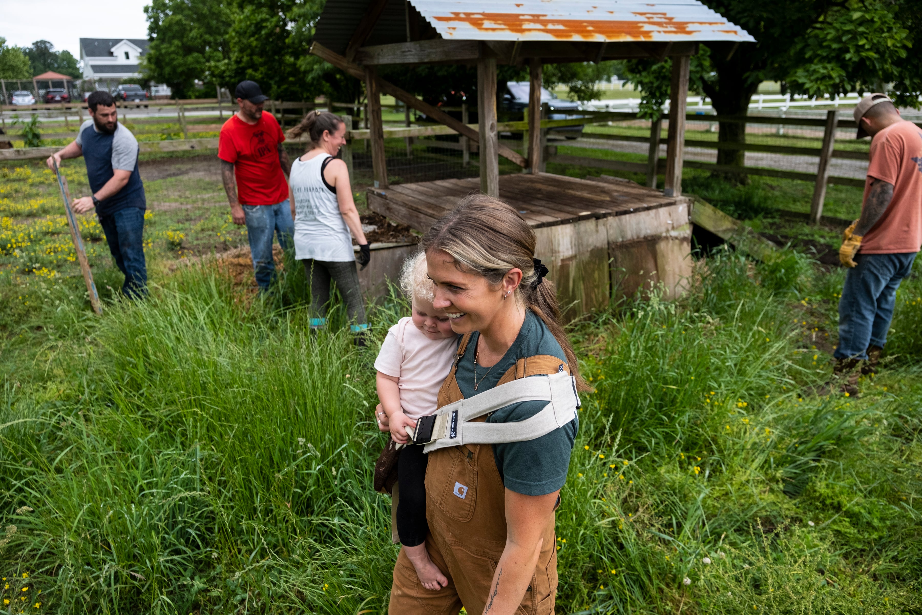 Kayla Arestivo, a therapist with Trails of Purpose, watches as volunteers help move bales of hay on  May 20, 2023, in Chesapeake, Va., ahead of the opening of their new location in Virginia Beach, Va.