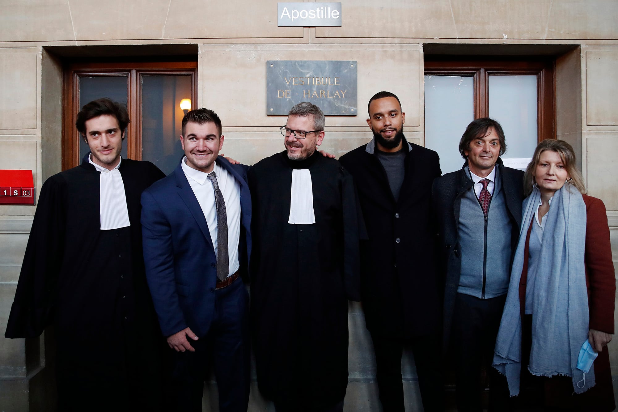 From left, lawyer Louis Cailliez, Alek Skarlatos, lawyer Thibault de Montbrial, Anthony Sadler, Mark Moogalian and Isabelle Risacher Moogalian, pose at the end of their hearing during the Thalys attack trial at the Paris courthouse, Friday, Nov. 20, 2020.