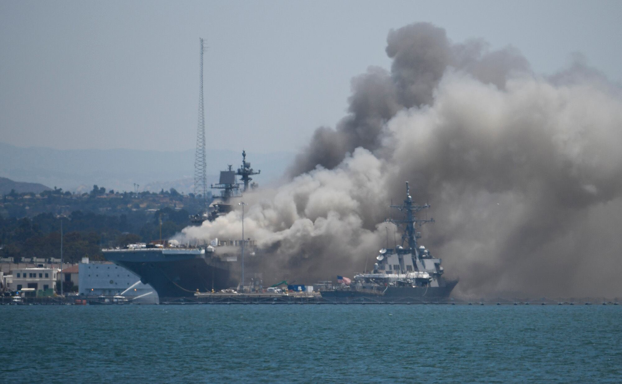 Smoke rises from the USS Bonhomme Richard at Naval Base San Diego Sunday, July 12, 2020, in San Diego after an explosion and fire Sunday on board the ship at Naval Base San Diego.