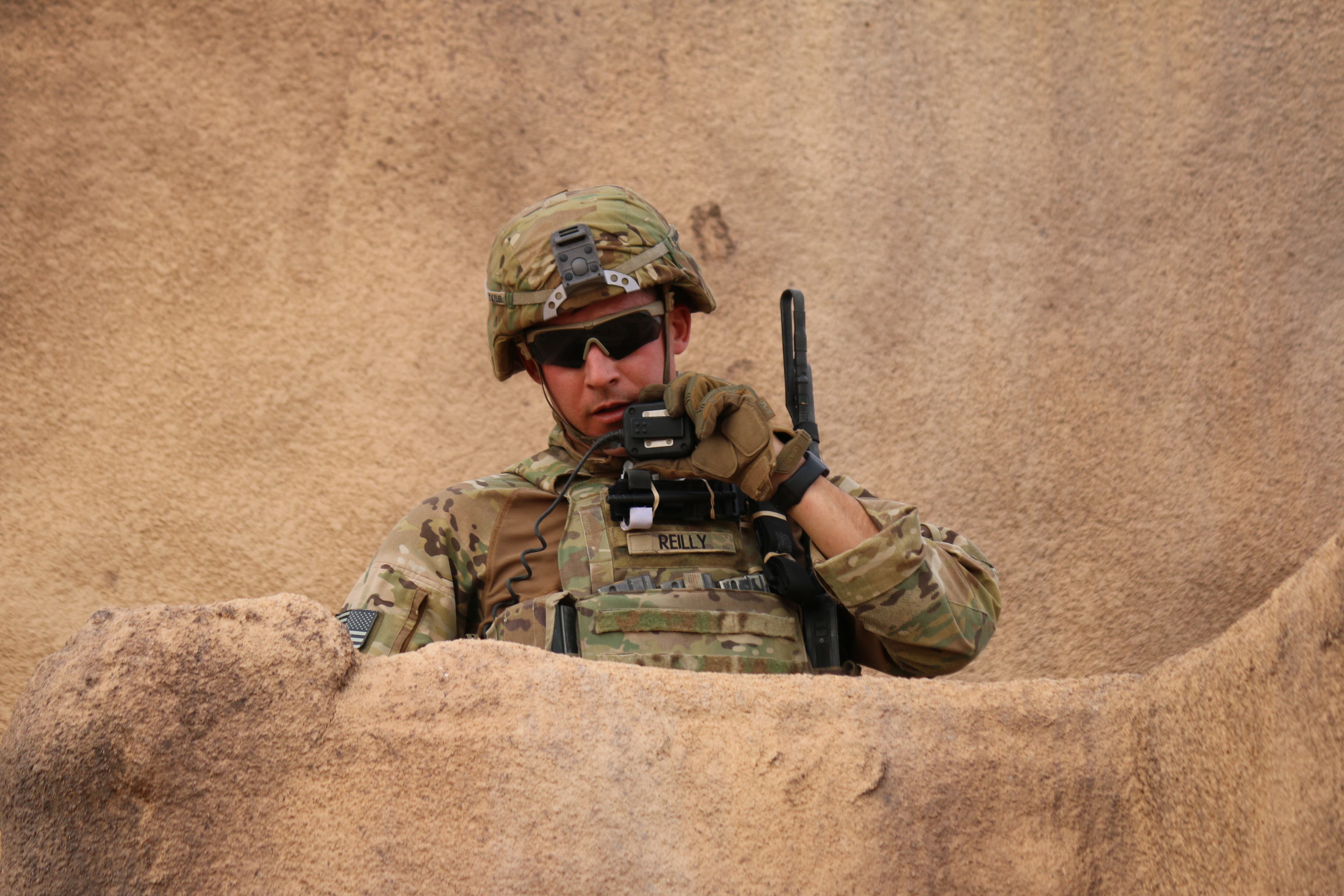 U.S. Army Cpl. Tyler Reilly, an infantryman, radios in his situation report after clearing a mock building during training in 2018 at Fort Bliss, Texas.