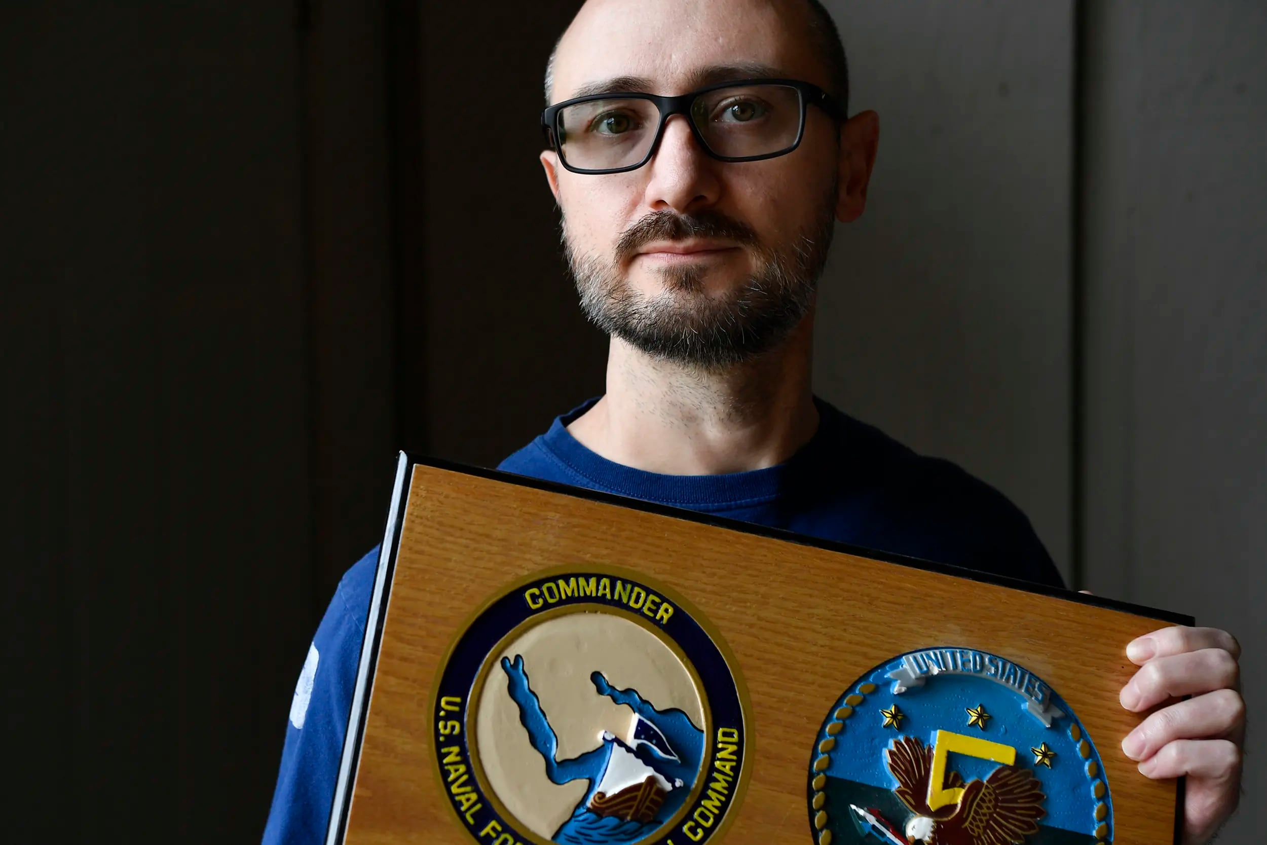 Jim Peckey, a former U.S. Navy petty officer now living in Abilene, holds a plaque honoring his service.