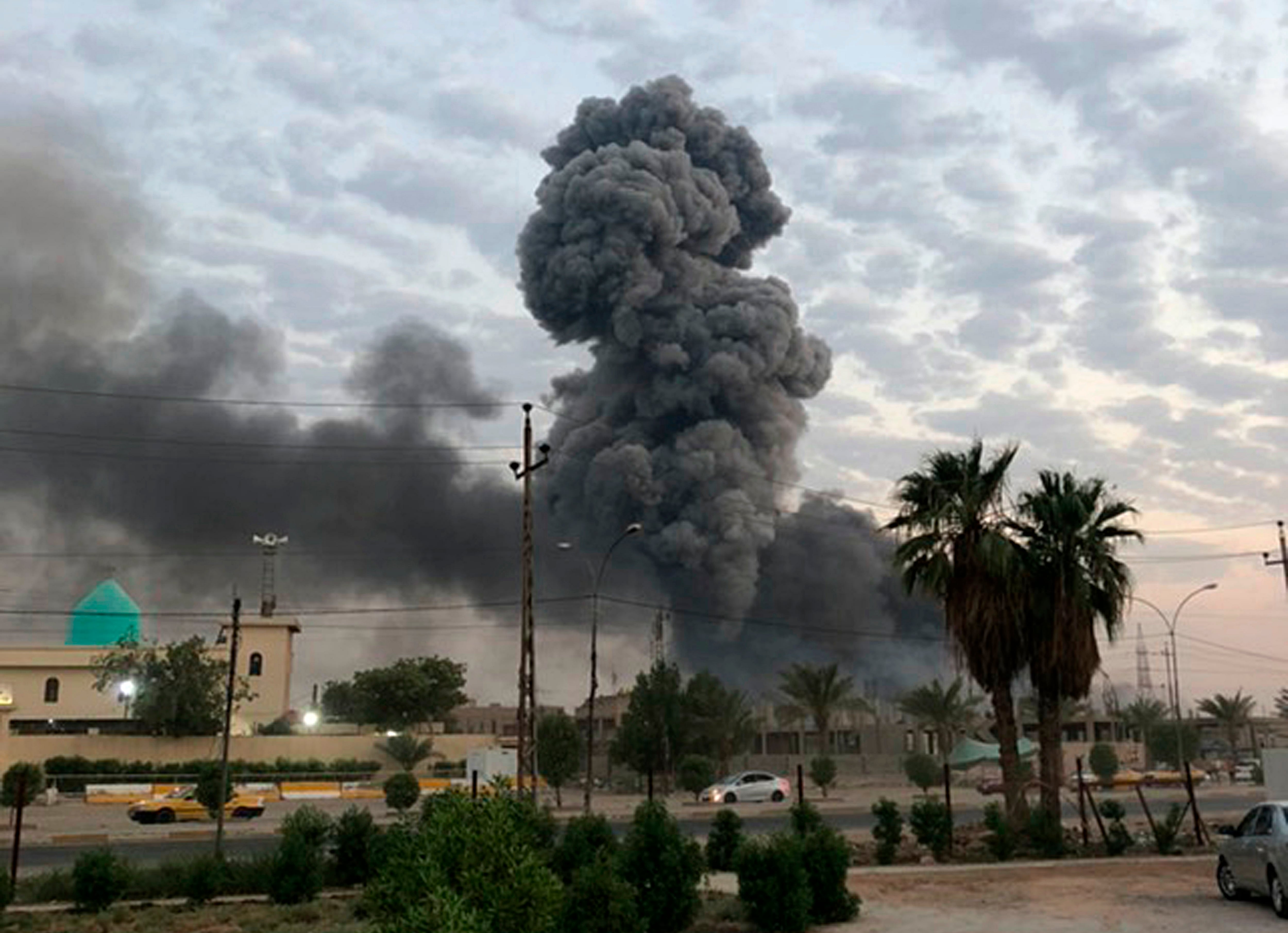 In this Monday, Aug. 12, 2019, photo, plumes of smoke rise after an explosion at a military base southwest of Baghdad, Iraq.