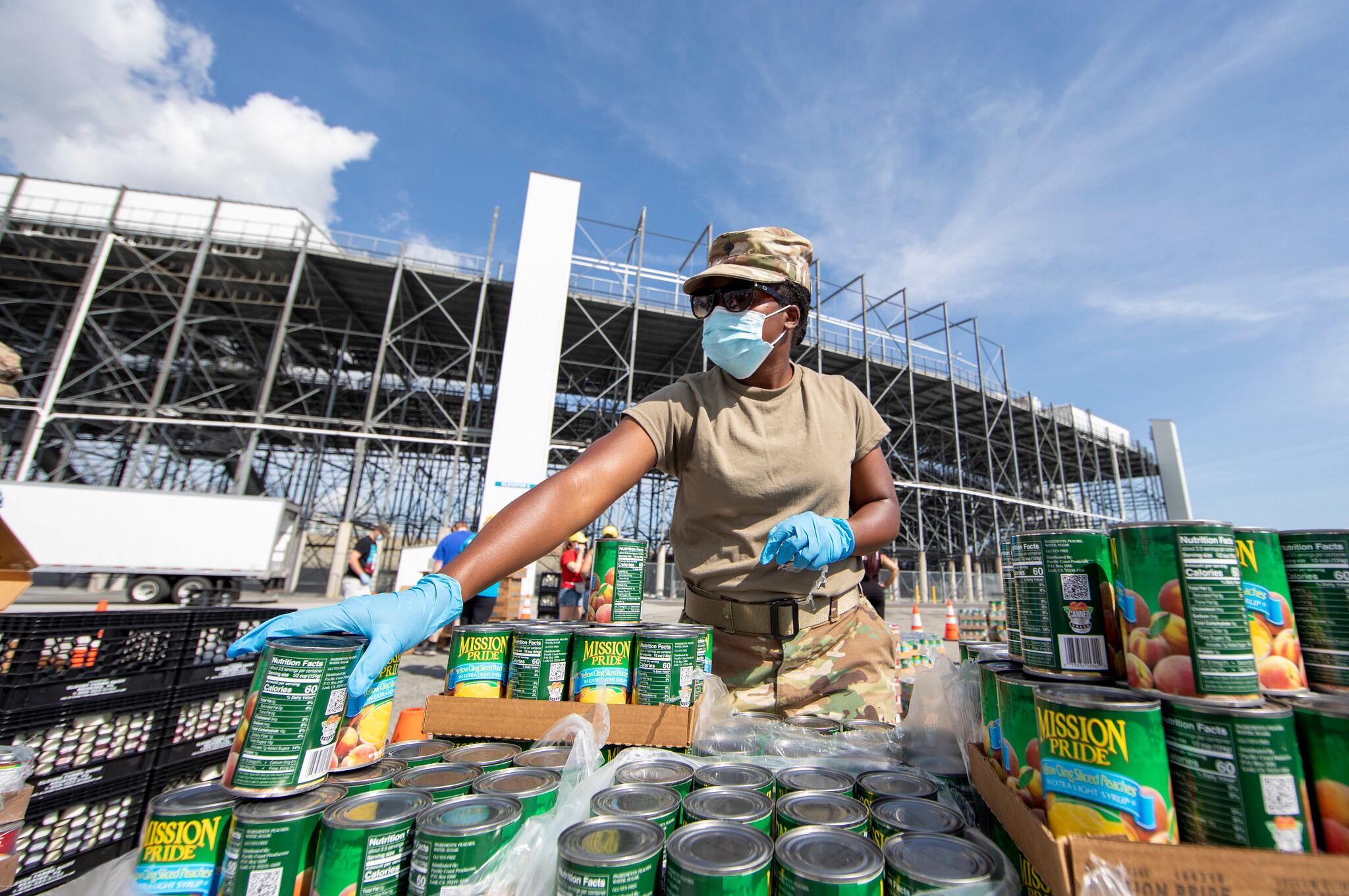 U.S. Army Spc. Ashley Jacobs, a combat medic with the Delaware Army National Guard Medical Detachment, organizes canned goods during a drive-thru food pantry on the grounds of Dover International Speedway in Dover, Del., June 24, 2020.