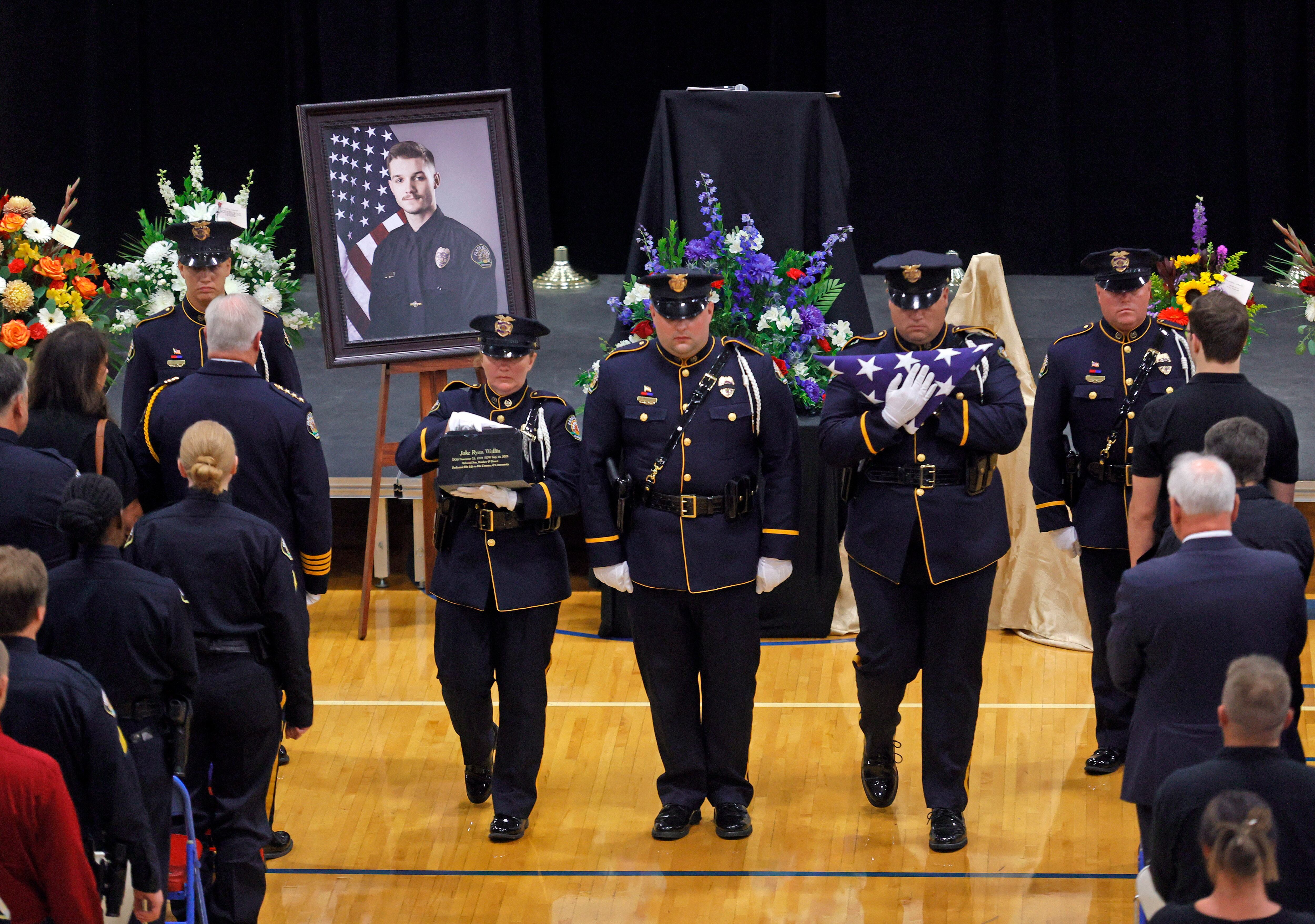 Fargo Police Department Honor Guard members carry a memorial urn and flag at the close of funeral services for Fargo Police Officer Jake Wallin at Pequot Lakes High School in Pequot Lakes, Minn., on Saturday, July 22, 2023