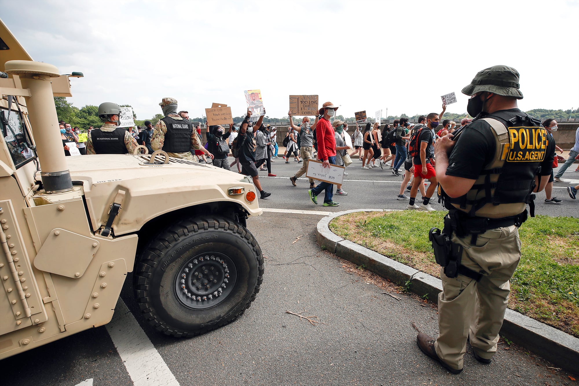 DC National Guard soldiers and other law enforcement personnel watch as demonstrators protest Saturday, June 6, 2020, along Independence Avenue in Washington, over the death of George Floyd, a black man who was in police custody in Minneapolis.