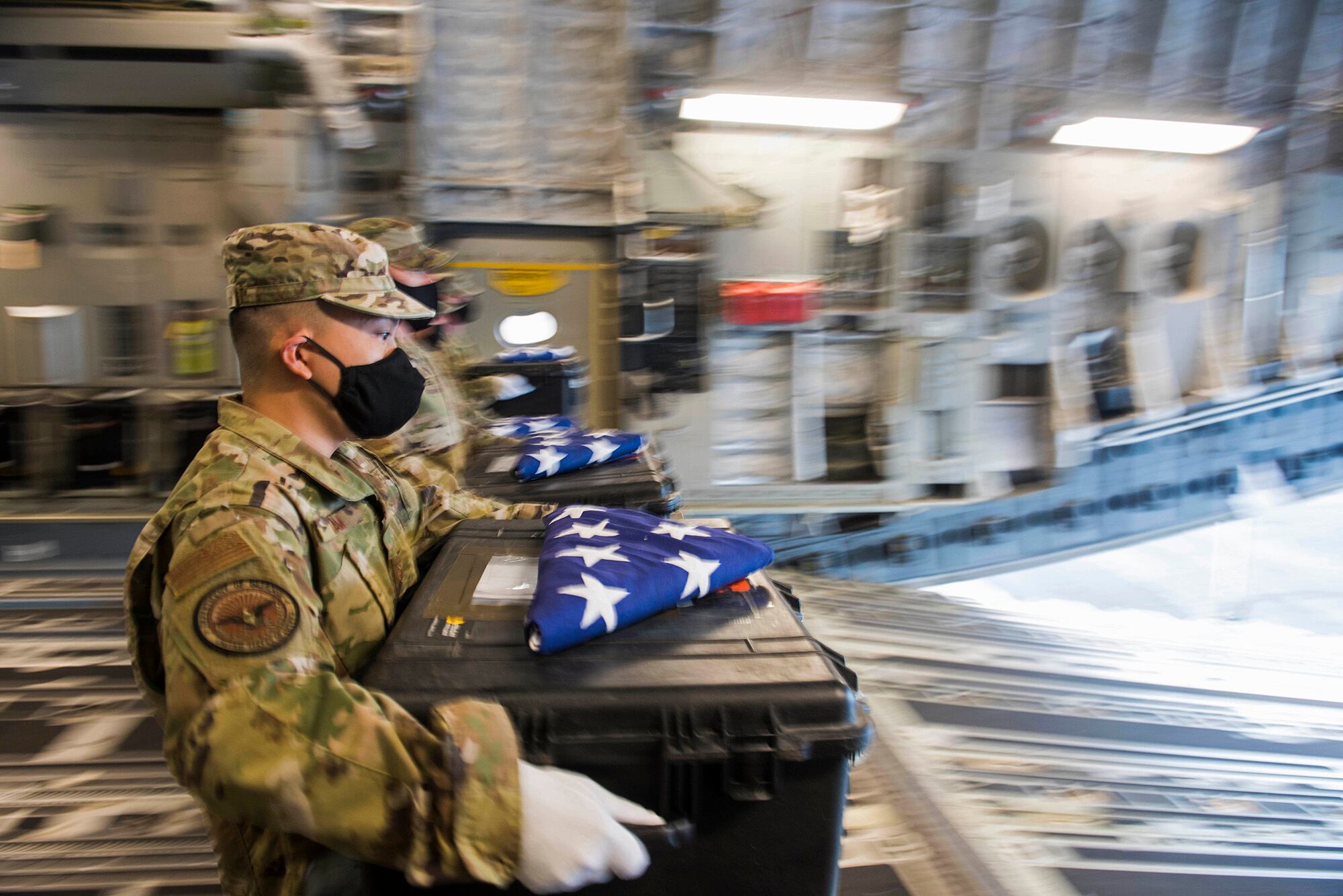 Members of the Defense POW/MIA Accounting Agency (DPAA) conduct an honorable carry for the remains of unidentified U.S. service members at Joint Base Pearl Harbor-Hickam, Hawaii, Dec. 21, 2020.