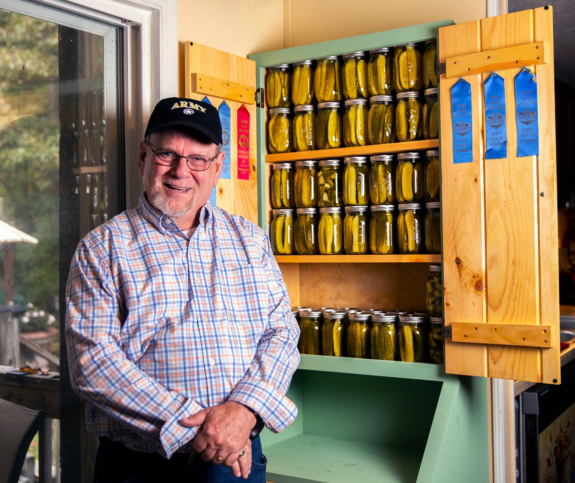 Boyd Elliott smiles in front of his pickle cabinet in his home in Louisa County on Thursday, Oct. 13, 2022 in Fredericksburg, Va.