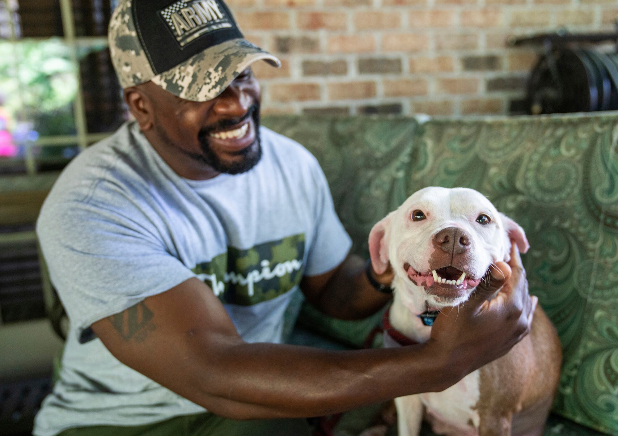 Omar Brooks pets Maisie Mae, a foster dog at Bridge To Home Animal Rescue on Monday, July 6, 2020, in Eighty Four, Pa.