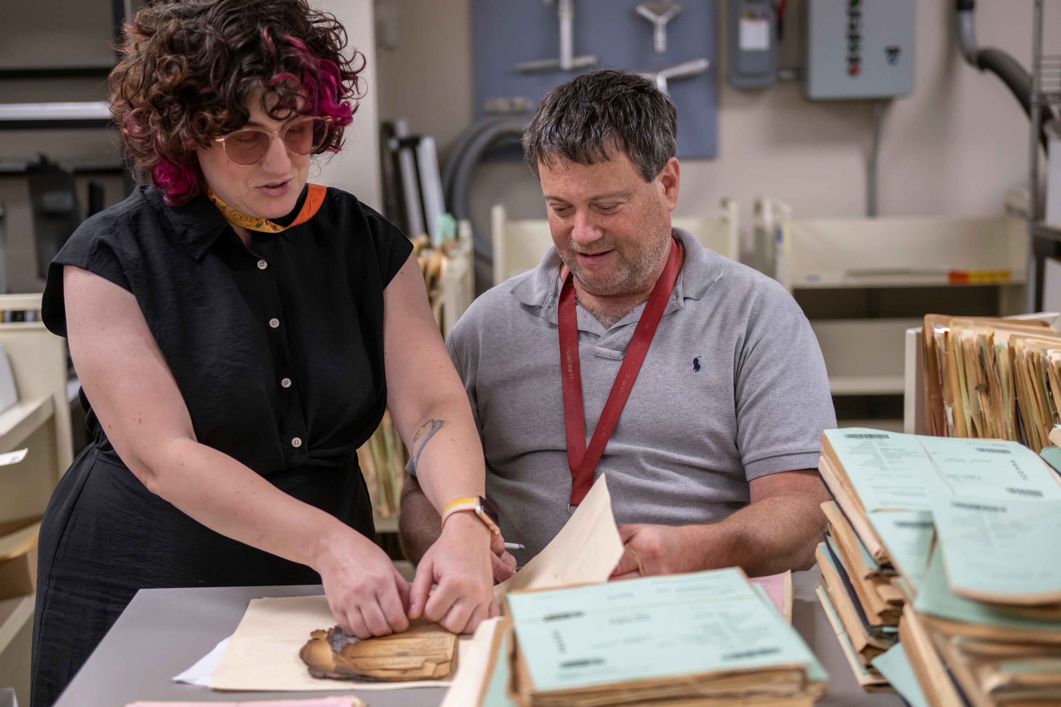 Ashley Cox, a preservation specialist at the National Archives and Records Administration, and NARA Preservation Technician Tom Schmidt assess a record's condition at the National Personnel Records Center in Spanish Lake, Mo., near St. Louis, on June 2, 2023.