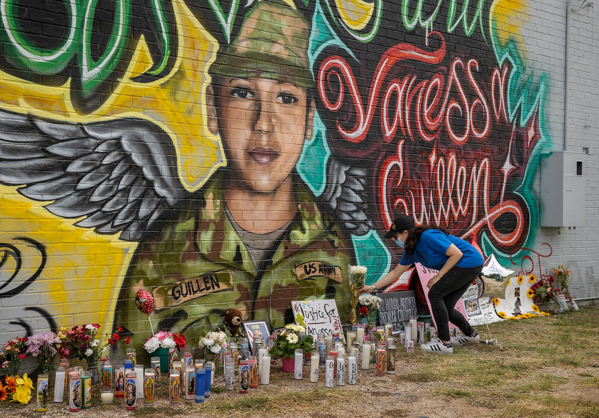 Mellisa Mendoza places white roses at a mural for Army Spc. Vanessa Guillen in Austin, Texas, on July 6, 2020.