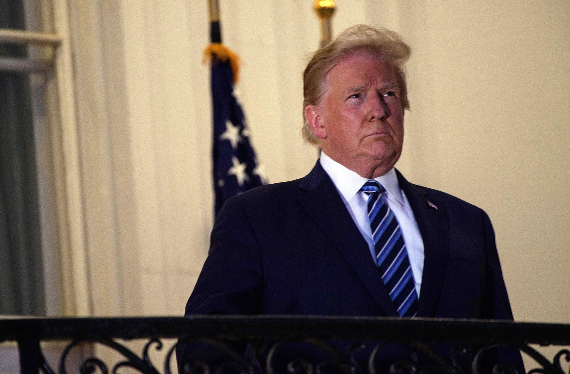 President Donald Trump looks out from the Truman Balcony upon his return to the White House from Walter Reed Medical Center, where he underwent treatment for COVID-19, in Washington on Oct. 5, 2020.