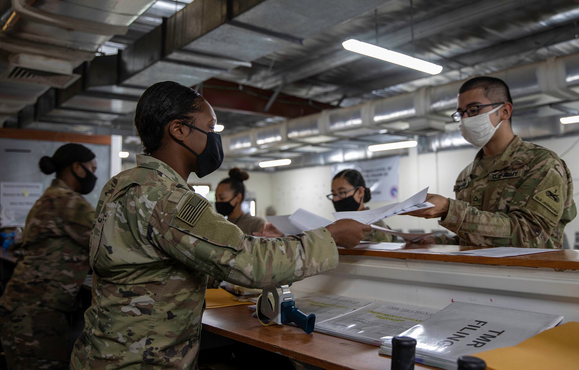 Army 2nd Lt. Daii Gardner and Spc. Natasha Washington hand out voting ballots to soldiers at the Theater Gateway, Camp Arifjan, Kuwait, Oct. 21, 2020.