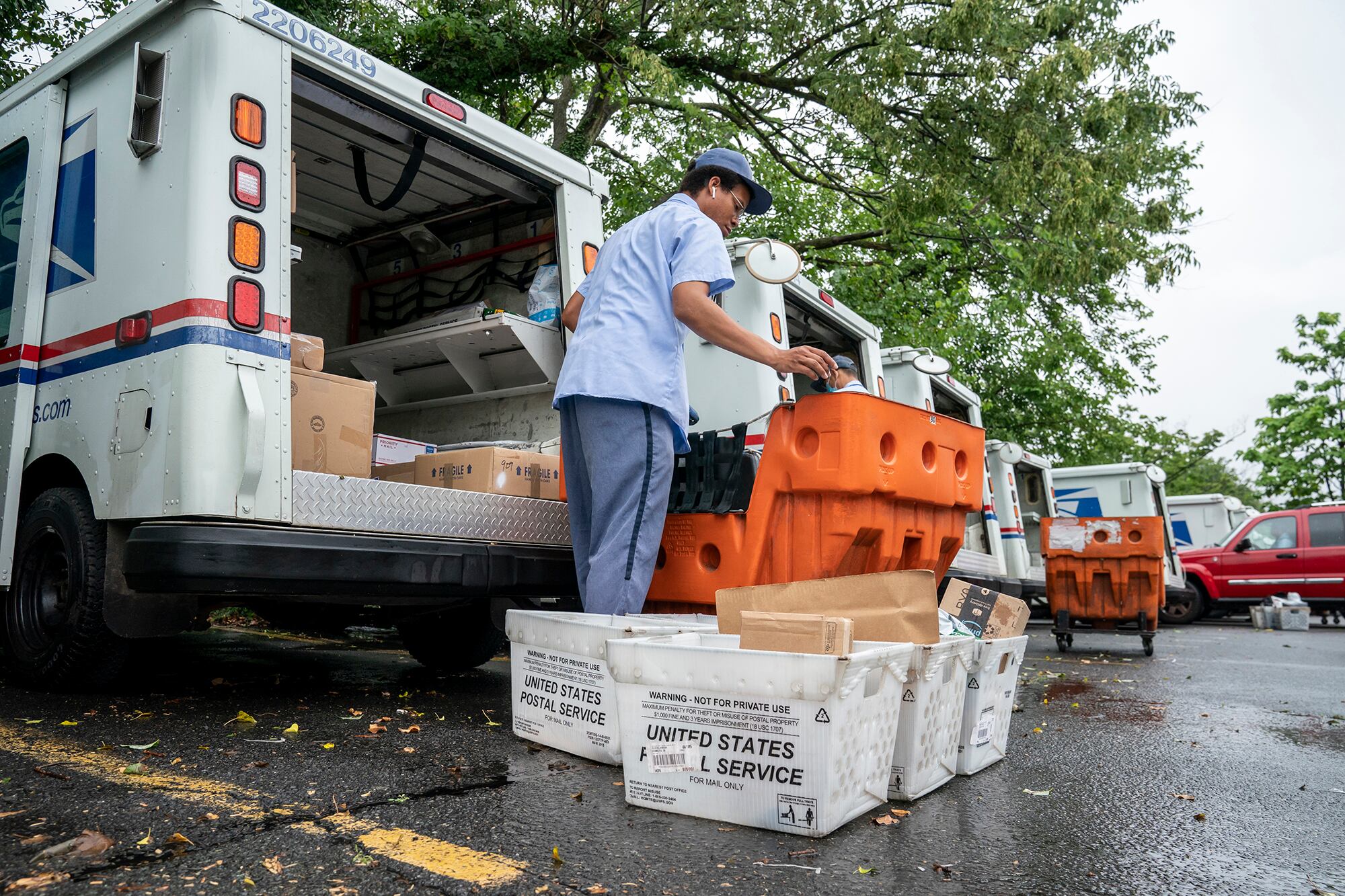 Letter carriers load mail trucks for deliveries at a U.S. Postal Service facility in McLean, Va., Friday, July 31, 2020.