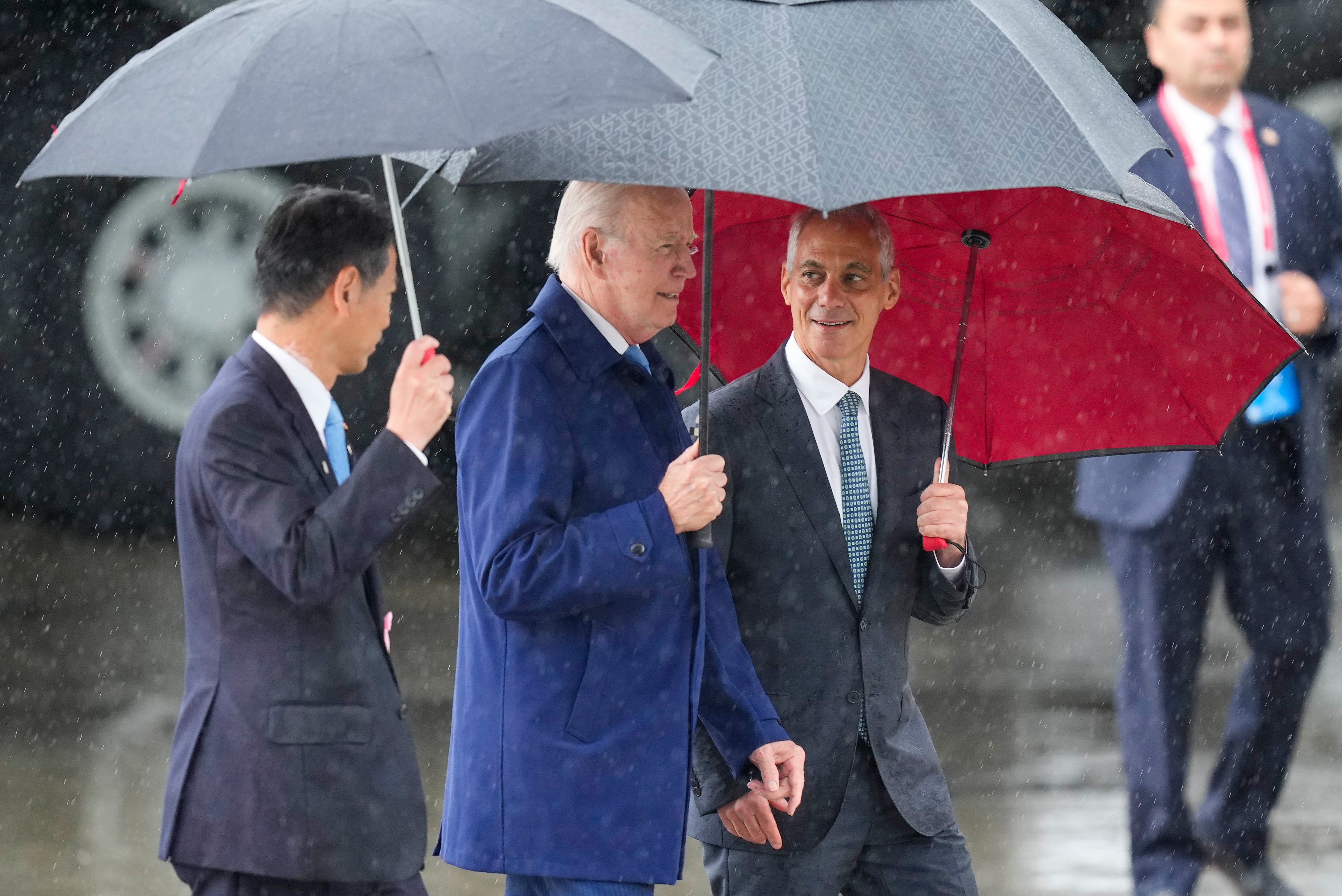 U.S. President Joe Biden, center, walks with Kenji Yamada, Japanese deputy minister of foreign affairs, left, and U.S. Ambassador to Japan Rahm Emanuel, right, after his arrival at Marine Corps Air Station Iwakuni, western Japan, Thursday, May 18, 2023, en route to Hiroshima for the Group of Seven nations' summit that starts Friday.