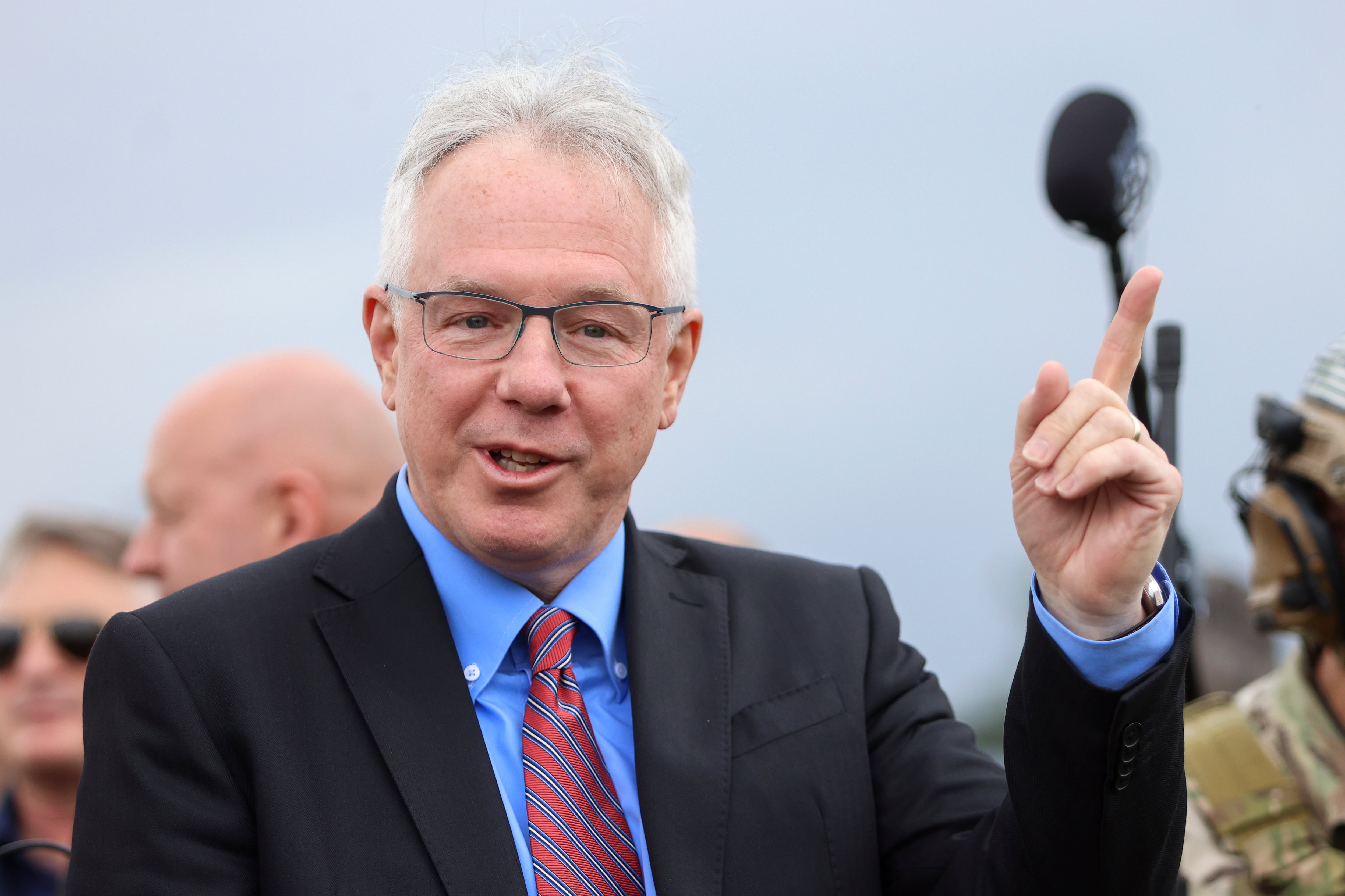 The United States Ambassador to Bosnia and Herzegovina Michael J. Murphy gestures towards the sky as he waits for the flight of Air Force B-1B Lancer bomber over Sarajevo, Bosnia, Tuesday, May 30, 2023.