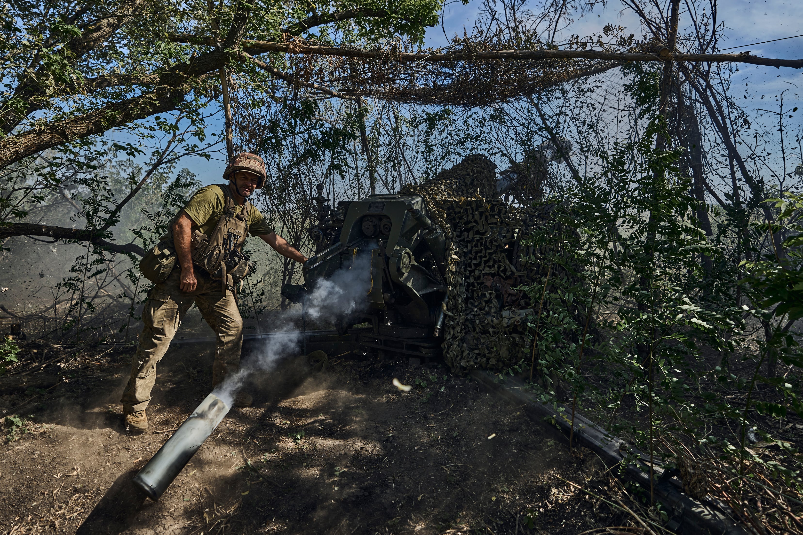 A Ukrainian serviceman of the 31 Brigade fires a D-30 cannon towards Russian positions at the front line in Donetsk region, Ukraine, Wednesday, Aug. 9, 2023.