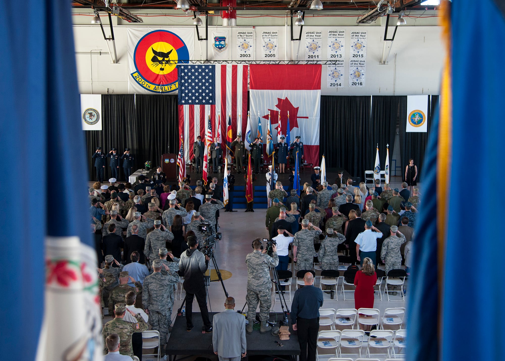 Members of both the North American Aerospace Defense Command and Northern Command, and international dignitaries from Mexico and Canada pay respects during the playing of the national anthem at the NORAD and USNORTHCOM change of command ceremony held on Peterson Air Force Base, Colo., May 24, 2018.