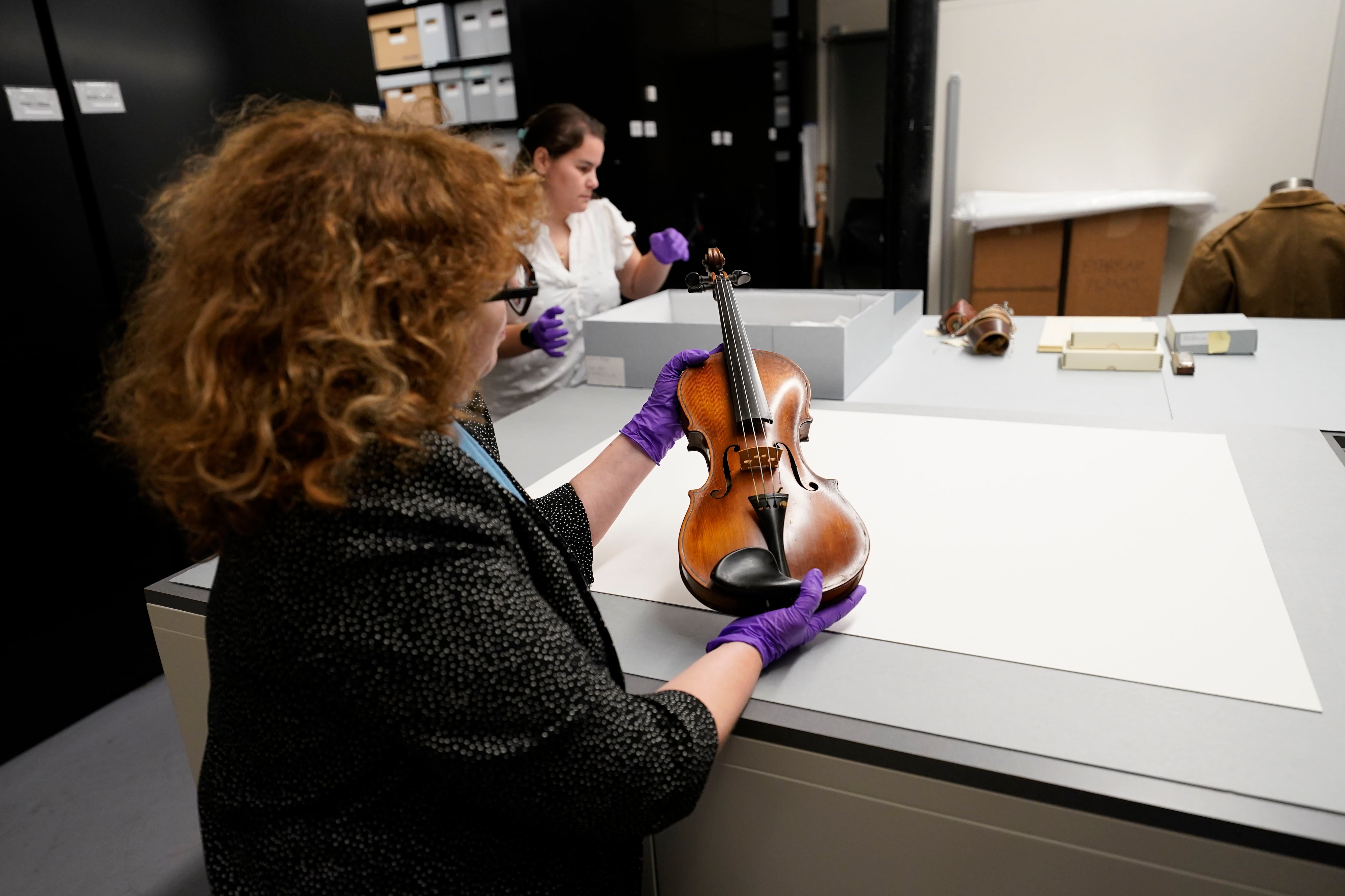 Kim Guise, curator for the National World War II Museum, shows a violin, hand made by Wilfred Lyon while a prisoner of the Germans, which will be on display at the new pavilion of the museum, in New Orleans, Friday, Sept. 29, 2023.