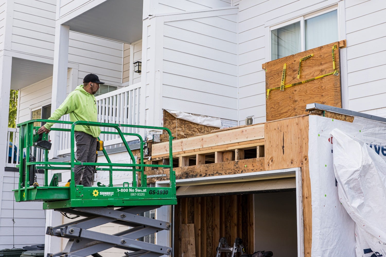 A worker treats wood affected by mold at the back of a townhouse at Joint Base Lewis-McChord. (Dan Delong/InvestigateWest)