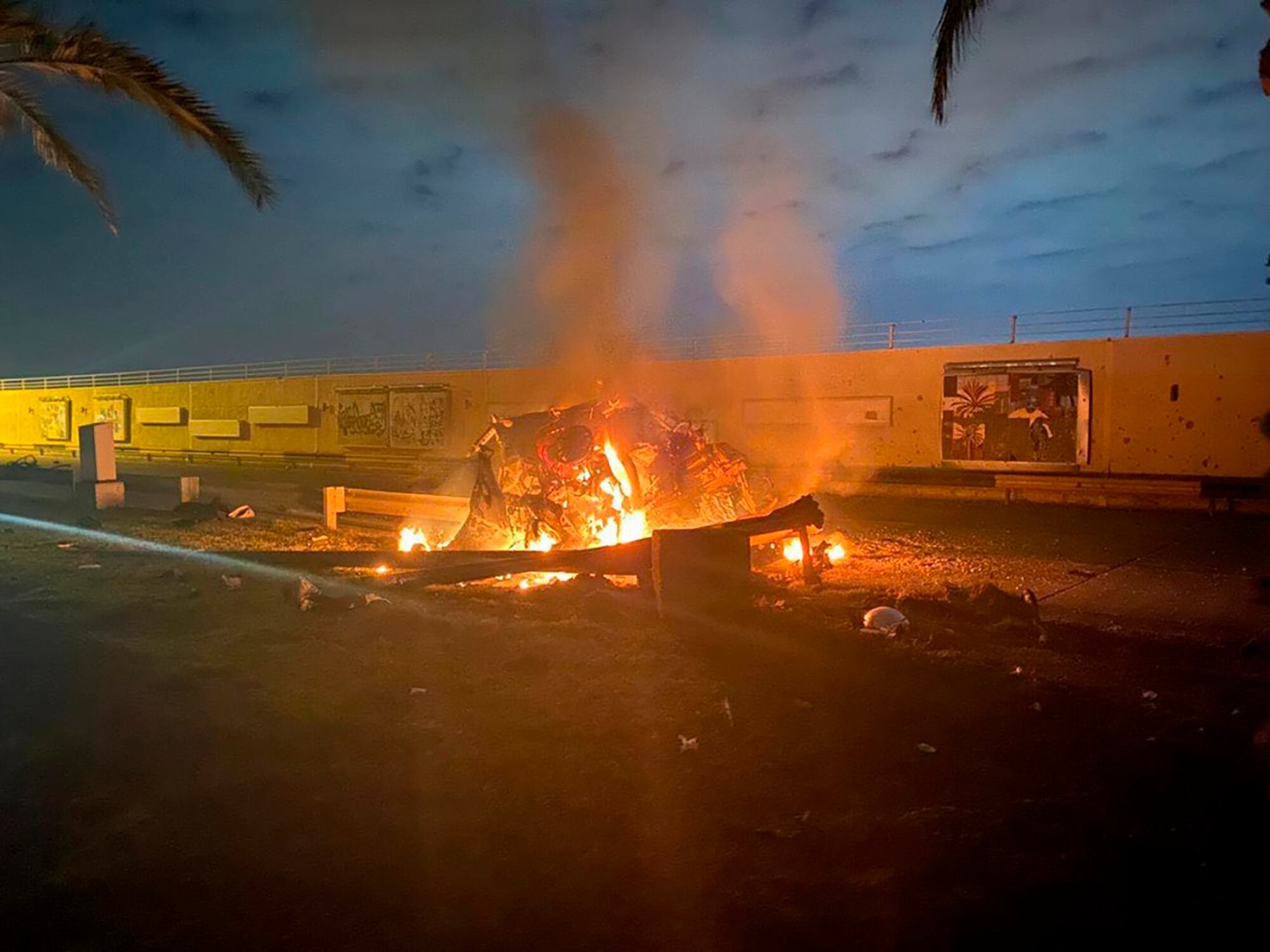 This Jan. 3, 2020, file photo, released by the Iraqi Prime Minister Press Office shows a burning vehicle at the Baghdad International Airport following a deadly airstrike in Baghdad, Iraq.