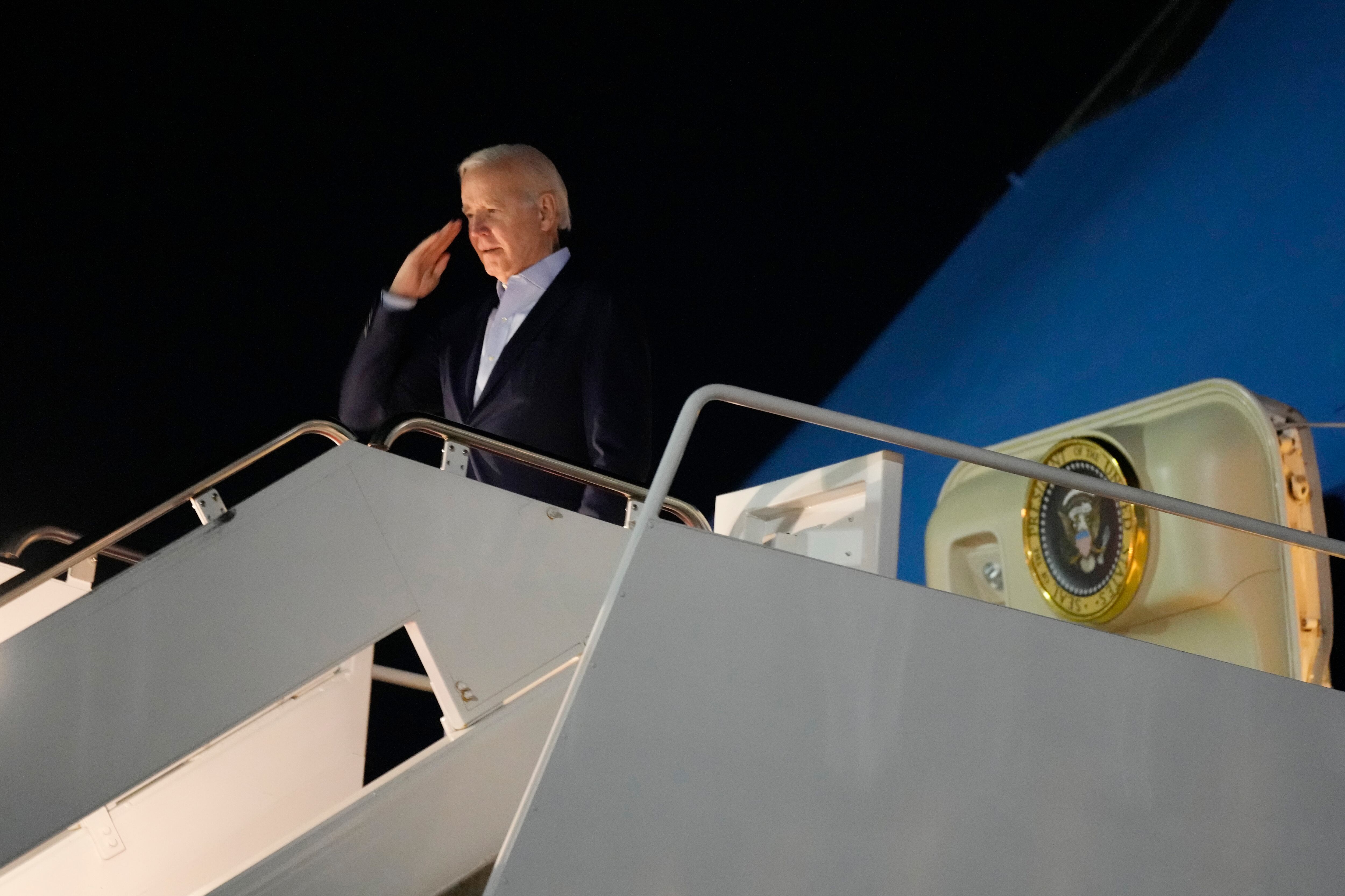 President Joe Biden salutes as he boards Air Force One at Andrews Air Force Base, Md., on Tuesday, Dec. 27, 2022.